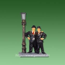 Dekorationsfigur Dick und Doof stehen neben einer Lampe